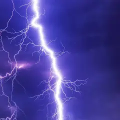Potężne wyładowanie atmosferyczne rozświetla nocne niebo. Takie przepięcie prądu może spowodować szkody, ale warto pamiętać o możliwości uzyskania odszkodowania.