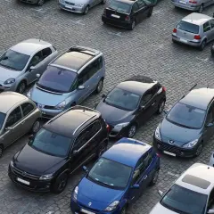 Parking tylko dla mieszkańców, mandat grozi za parkowanie. Wiele samochodów na brukowanym placu.
