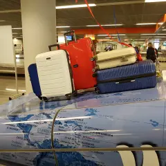 Stojaki z bagażami na mapie świata. Może to być symboliczna dzienna dieta za opóźniony bagaż, gdy podróżni czekają na swoje rzeczy.