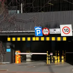 Znaki drogowe przy wjeździe na parking pod blokiem: zakaz wjazdu pojazdów o wysokości powyżej 2m, strefa ruchu, ograniczenie prędkości do 10 km/h.