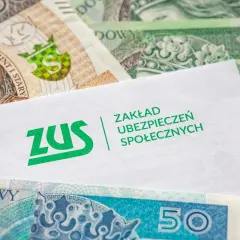 Koperta z logo ZUS na tle polskich banknotów. Symbolizuje opłacanie składek ZUS samemu, co jest ważnym elementem finansowej przyszłości.