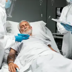 Lekarze w kombinezonach ochronnych przy łóżku pacjenta w stanie wegetatywnym. Czy szpital może wypisać pacjenta w stanie wegetatywnym?