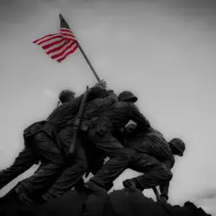 Pomnik żołnierzy wznoszących flagę USA. W obliczu niepewności, ubezpieczenie na wypadek wojny daje poczucie bezpieczeństwa.