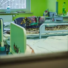 Pokój dziecięcy w szpitalu psychiatrycznym, łóżka z kolorowymi pościelami. Długi maksymalny czas pobytu w szpitalu psychiatrycznym może być trudny dla małych pacjentów.