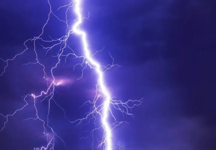 Potężne wyładowanie atmosferyczne rozświetla nocne niebo. Takie przepięcie prądu może spowodować szkody, ale warto pamiętać o możliwości uzyskania odszkodowania.