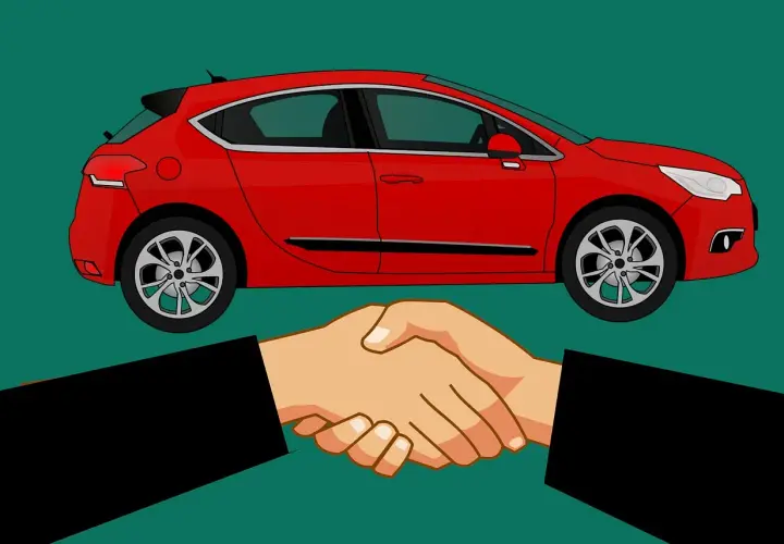 Sprzedałem auto i nie wypowiedziałem umowy OC. Dwie dłonie ściskają się na tle czerwonego samochodu.