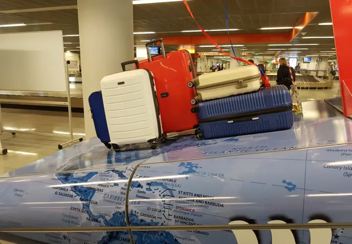 Stojaki z bagażami na mapie świata. Może to być symboliczna dzienna dieta za opóźniony bagaż, gdy podróżni czekają na swoje rzeczy.