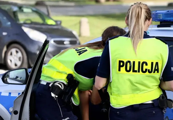 Policjantki w kamizelkach odblaskowych przy radiowozie. Czy trzeba mieć przy sobie OC? To pytanie zadaje sobie wielu kierowców.