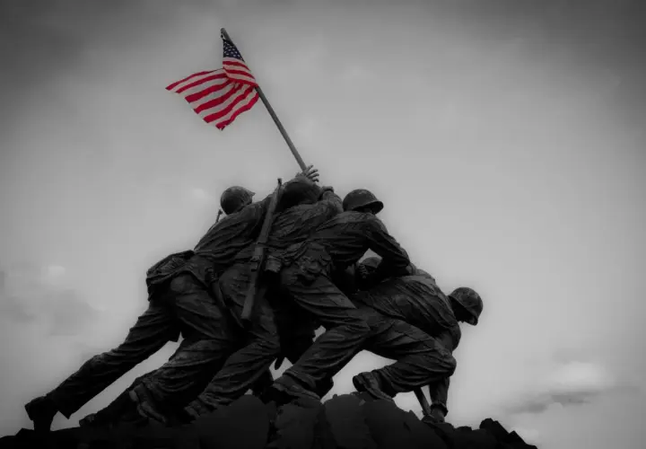 Pomnik żołnierzy wznoszących flagę USA. W obliczu niepewności, ubezpieczenie na wypadek wojny daje poczucie bezpieczeństwa.