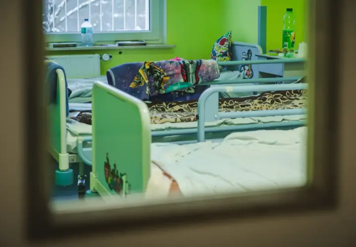 Pokój dziecięcy w szpitalu psychiatrycznym, łóżka z kolorowymi pościelami. Długi maksymalny czas pobytu w szpitalu psychiatrycznym może być trudny dla małych pacjentów.