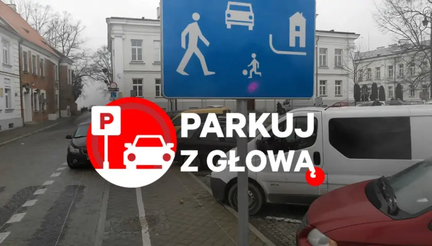 Strefa zamieszkania, brak wyznaczonych miejsc do parkowania. Znak "Parkuj z głową" przypomina o ostrożności.