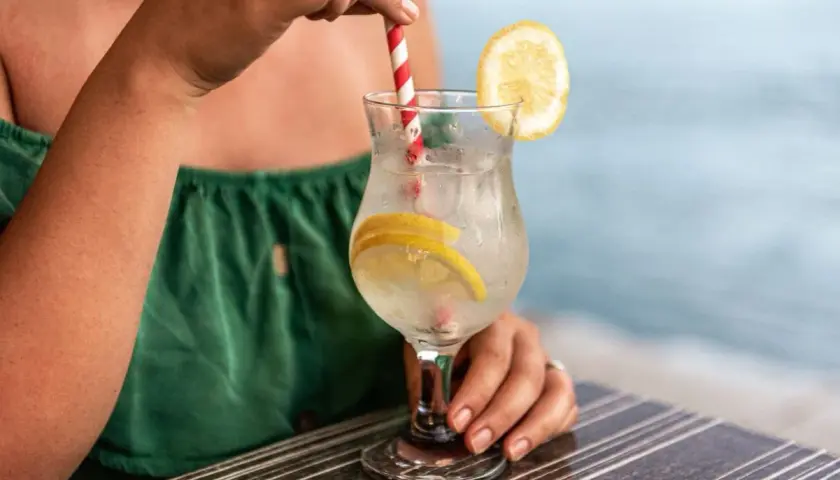 Relaks przy drinku z cytryną. Pamiętaj o ubezpieczeniu turystycznym z klauzulą alkoholową, by wakacje były bezpieczne.