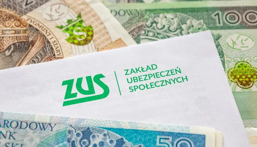 Koperta z logo ZUS na tle polskich banknotów. Symbolizuje opłacanie składek ZUS samemu, co jest ważnym elementem finansowej przyszłości.