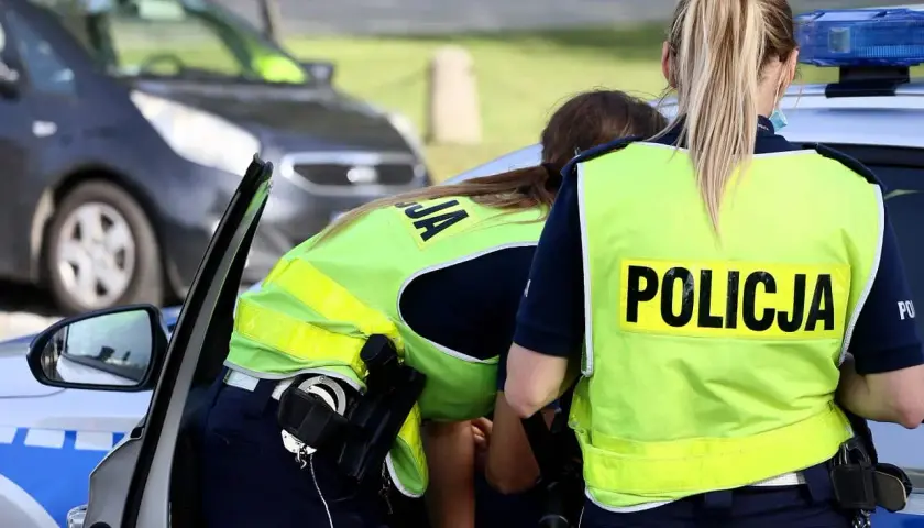 Policjantki w kamizelkach odblaskowych przy radiowozie. Czy trzeba mieć przy sobie OC? To pytanie zadaje sobie wielu kierowców.