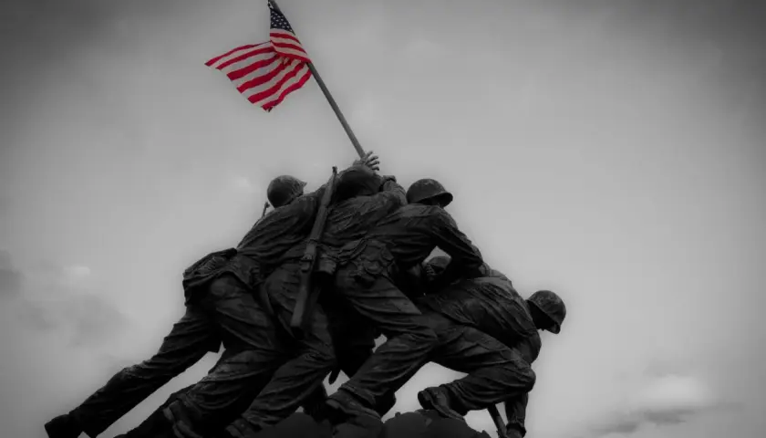 Pomnik żołnierzy wznoszących flagę USA. W obliczu niepewności, ubezpieczenie na wypadek wojny daje poczucie bezpieczeństwa.