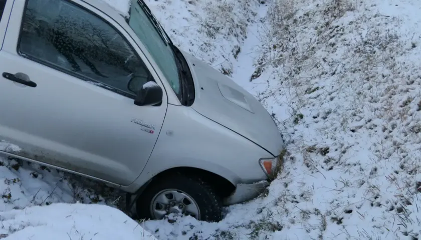 Srebrny pickup wpadł do rowu w śniegu. Kierowca pewnie żałuje, że pierwsza rata OC po terminie, bo teraz czeka go laweta.
