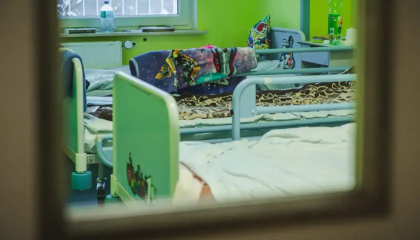 Pokój dziecięcy w szpitalu psychiatrycznym, łóżka z kolorowymi pościelami. Długi maksymalny czas pobytu w szpitalu psychiatrycznym może być trudny dla małych pacjentów.