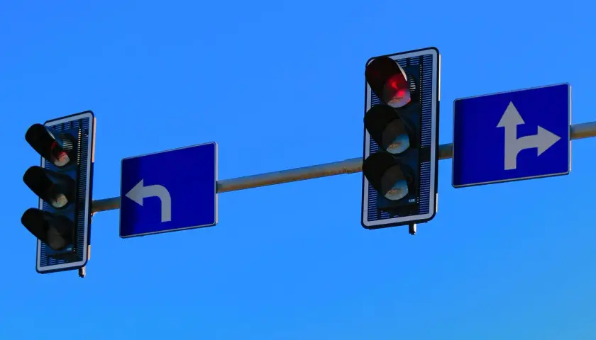 Sygnalizacja bezkolizyjna: czerwone światło i znaki kierunkowe informują o dozwolonych kierunkach jazdy.