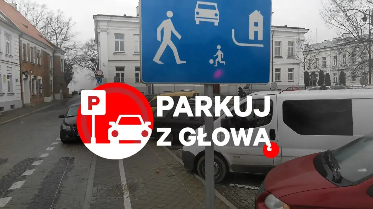 Strefa zamieszkania, brak wyznaczonych miejsc do parkowania. Znak "Parkuj z głową" przypomina o ostrożności.
