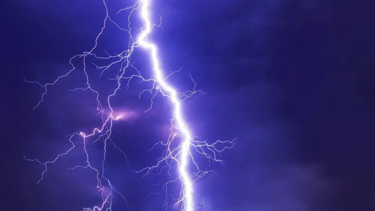 Potężne wyładowanie atmosferyczne rozświetla nocne niebo. Takie przepięcie prądu może spowodować szkody, ale warto pamiętać o możliwości uzyskania odszkodowania.