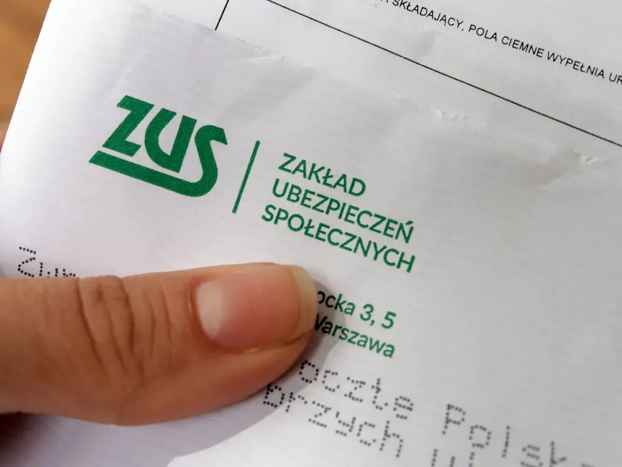 Zerwane więzadła w kolanie? ZUS może przyznać odszkodowanie. Na dokumencie logo ZUS i adres.