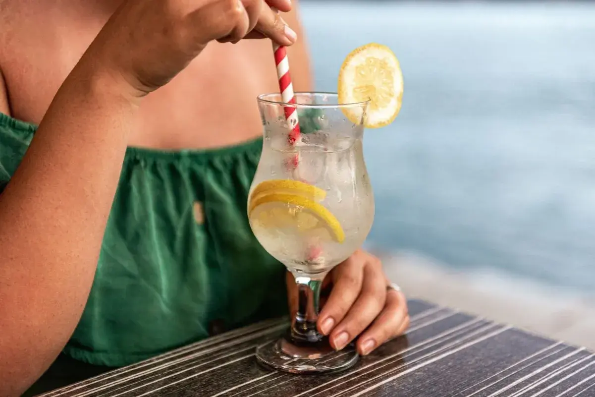 Relaks przy drinku z cytryną. Pamiętaj o ubezpieczeniu turystycznym z klauzulą alkoholową, by wakacje były bezpieczne.