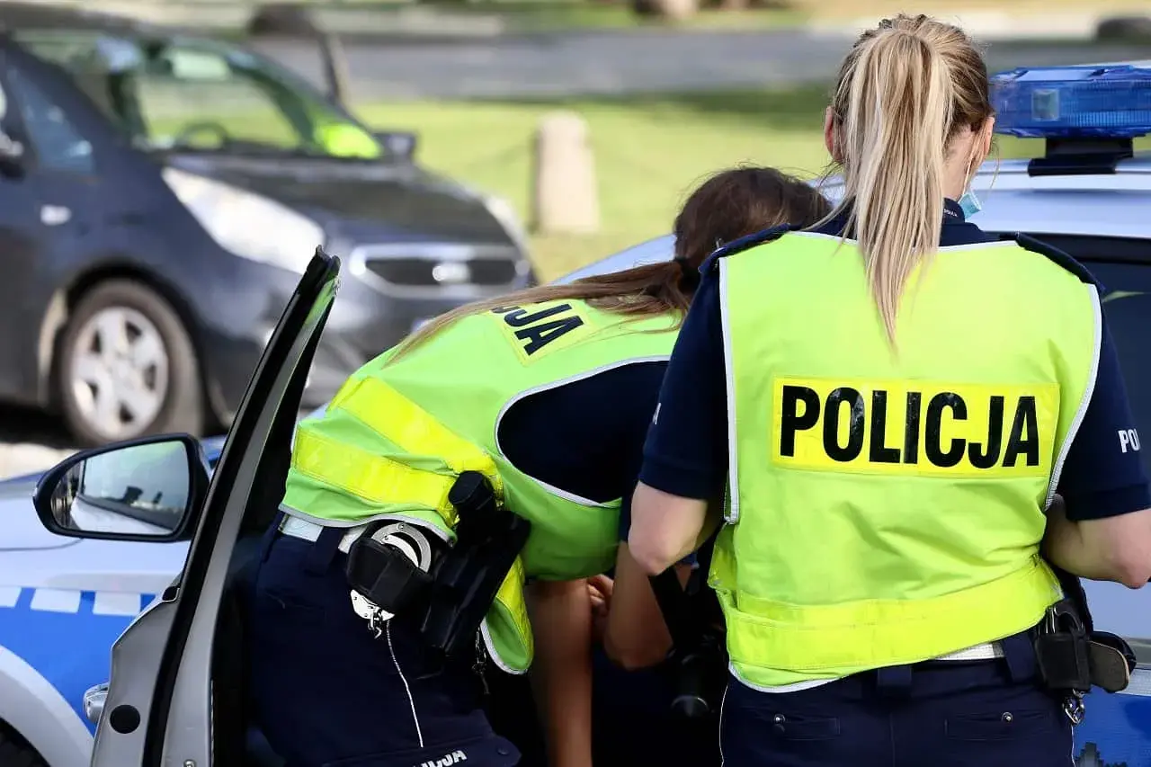 Policjantki w kamizelkach odblaskowych przy radiowozie. Czy trzeba mieć przy sobie OC? To pytanie zadaje sobie wielu kierowców.