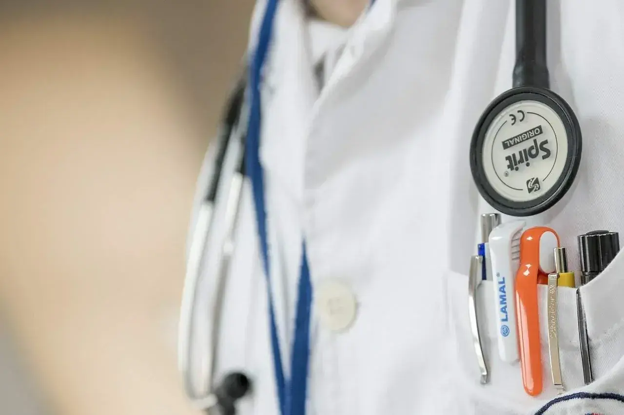 Lekarz w białym kitlu, z przypiętym stetoskopem, przygotowuje się do skierowania na badania psychiatryczne przez sąd.