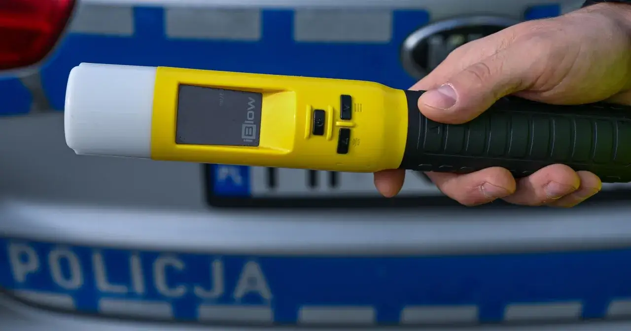 Dłoń trzyma alkomat. Wynik 0,13 promila to już mandat i utrata prawa jazdy.