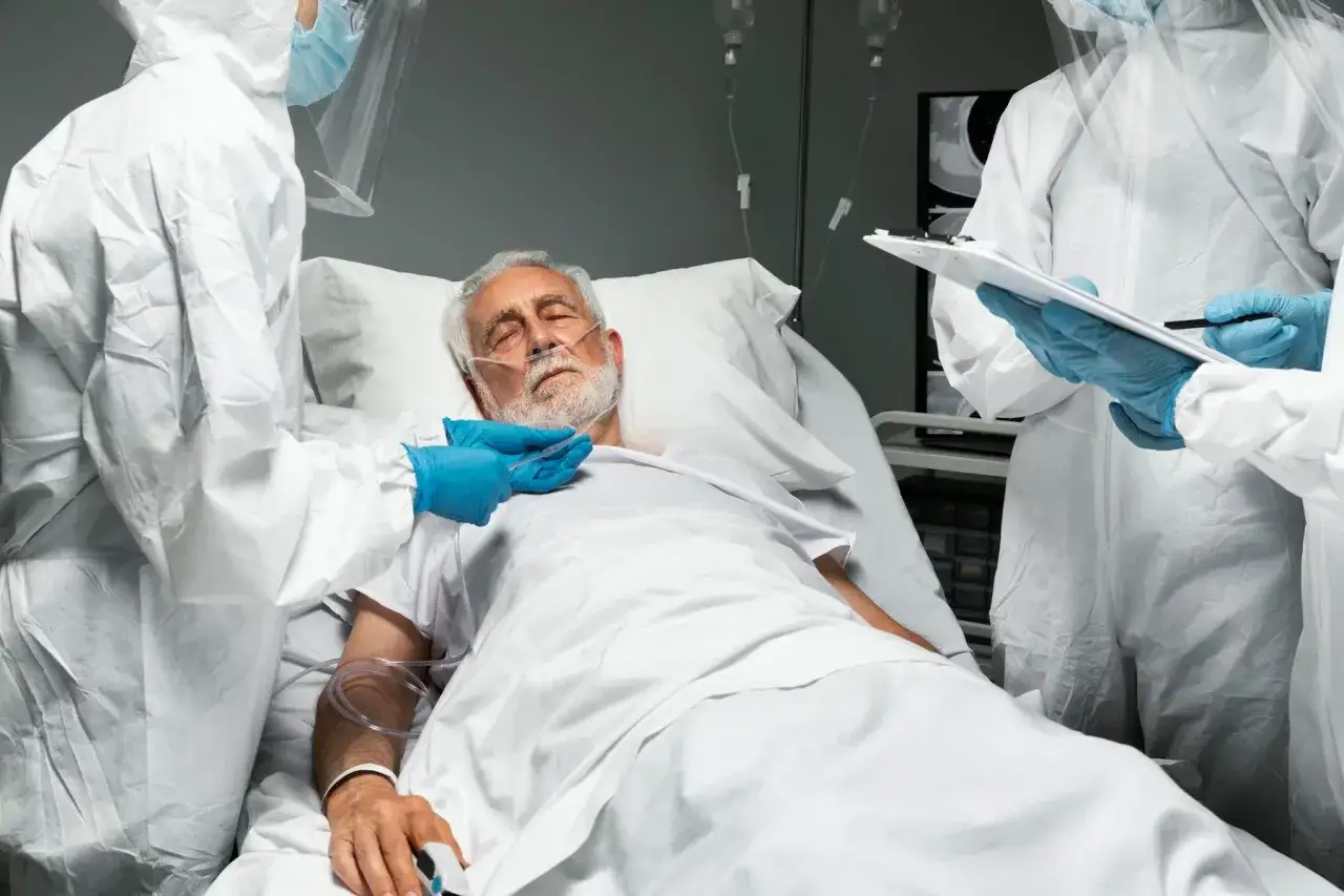 Lekarze w kombinezonach ochronnych nadzorują pacjenta w stanie wegetatywnym, zastanawiając się, czy szpital może go wypisać.