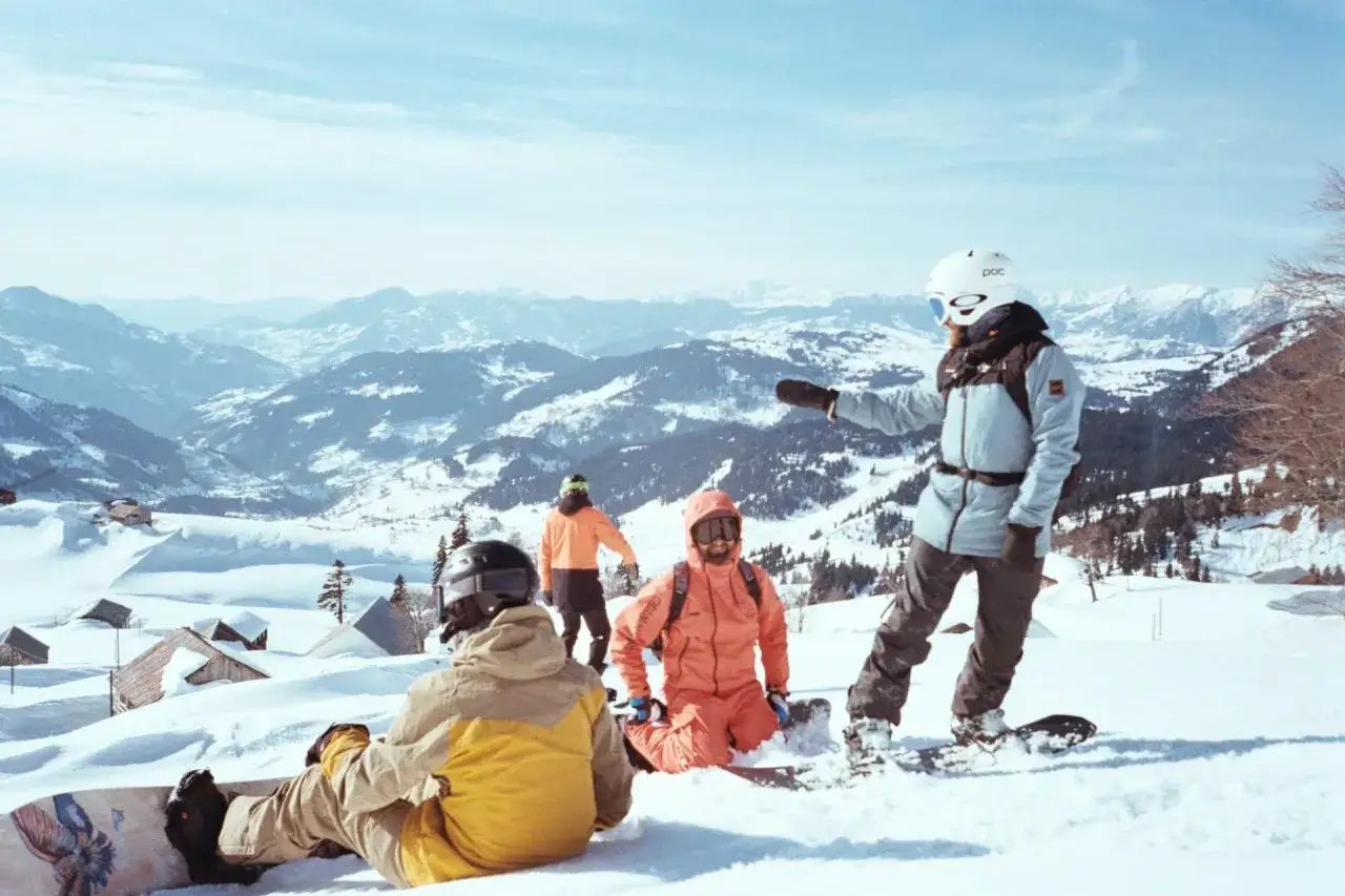 Grupa snowboardzistów na stoku we Włoszech. Warto mieć ubezpieczenie narciarskie Włochy, by cieszyć się zimowymi szaleństwami bez obaw.