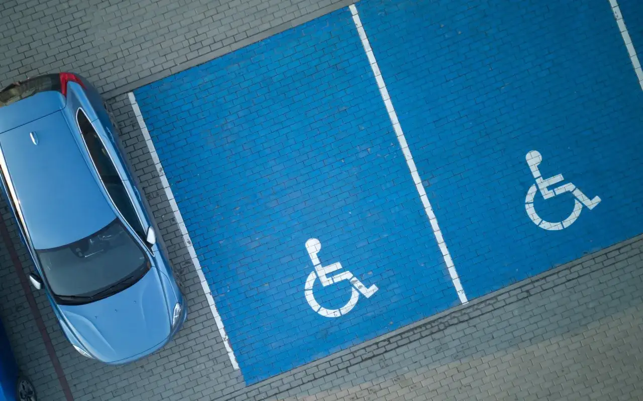Niebieskie miejsca parkingowe dla osób z niepełnosprawnościami. Zastanawiasz się, jak ubezpieczenie samochodu a stopień niepełnosprawności wpływają na Twoje prawa?